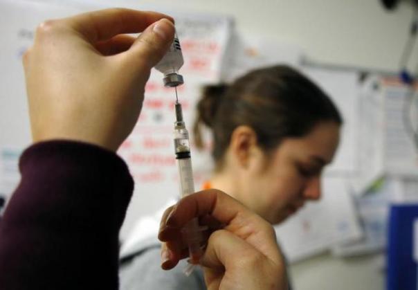 Nurses prepare influenza vaccine injections during a flu shot clinic in Boston